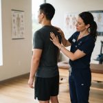 Chiropractor evaluating patient movement and posture in modern clinic